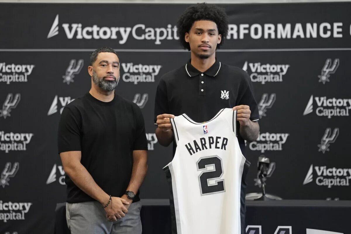 San Antonio first round draft pick Dylan Harper (2) holds up his jersey along with general manager Brian Wright at Victory Capital Performance Center.