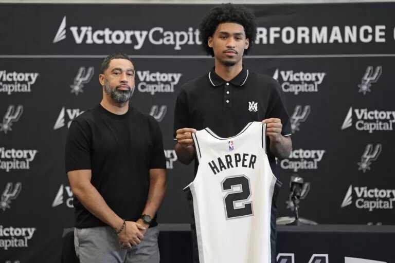San Antonio first round draft pick Dylan Harper (2) holds up his jersey along with general manager Brian Wright at Victory Capital Performance Center.