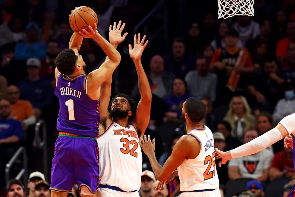 Nov 20, 2024; Phoenix, Arizona, USA; Phoenix Suns guard Devin Booker (1) shoots the ball against New York Knicks center Karl-Anthony Towns (32) during the third quarter at Footprint Center. Mandatory Credit: Mark J. Rebilas-Imagn Images