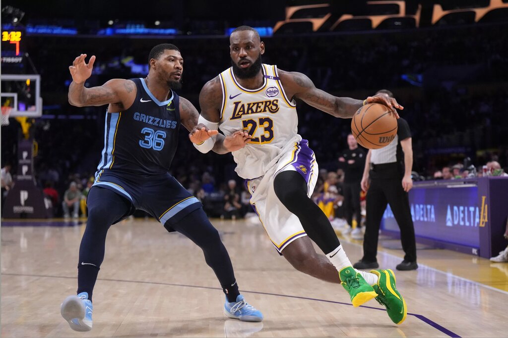 Dec 15, 2024; Los Angeles, California, USA; Los Angeles Lakers forward LeBron James (23) dribbles the ball against Memphis Grizzlies guard Marcus Smart (36) at Crypto.com Arena. Mandatory Credit: Kirby Lee-Imagn Images