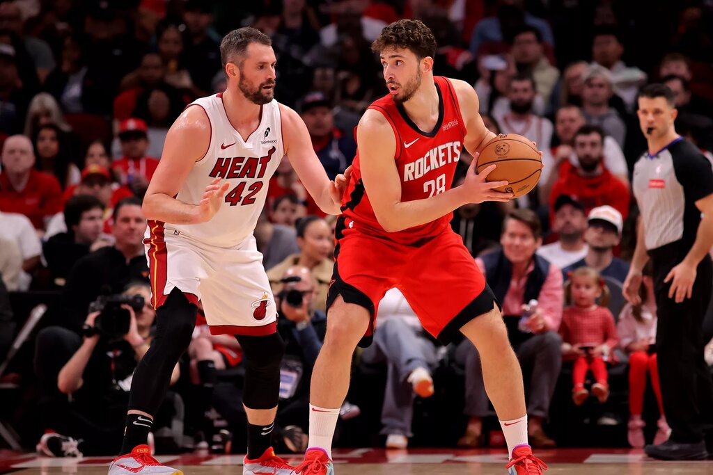 Dec 29, 2024; Houston, Texas, USA; Houston Rockets center Alperen Sengun (28) handles the ball against Miami Heat forward Kevin Love (42) during the third quarter at Toyota Center. Mandatory Credit: Erik Williams-Imagn Images