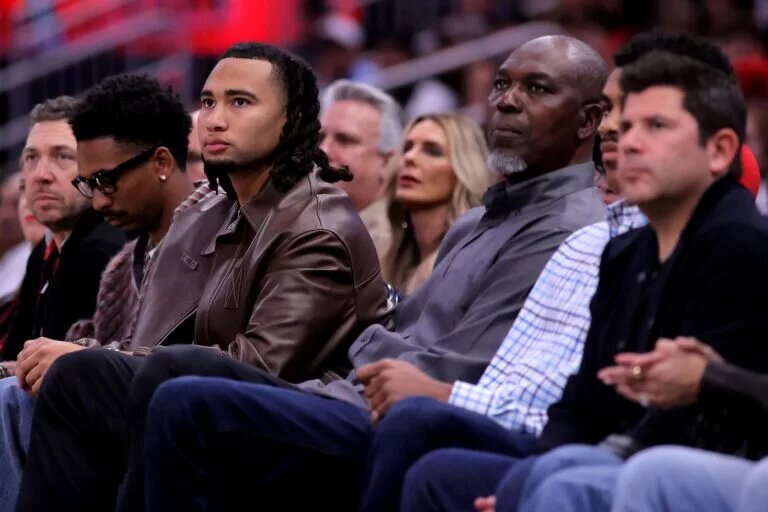 Apr 4, 2025; Houston, Texas, USA; Houston Texans quarterback C.J. Stroud sits courtside next to former Houston Rockets and Basketball Hall-of-Famer Hakeem Olajuwon during the first quarter between the Houston Rockets and the Oklahoma City Thunder at Toyota Center. Mandatory Credit: Erik Williams-Imagn Images