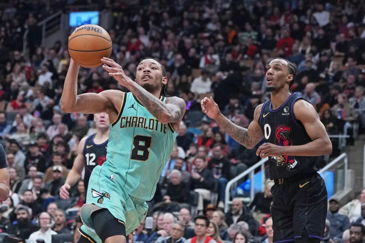 Apr 9, 2025; Toronto, Ontario, CAN; Charlotte Hornets guard Nick Smith Jr. (8) passes against Toronto Raptors guard A.J. Lawson (0) during the third quarter at Scotiabank Arena. Mandatory Credit: Nick Turchiaro-Imagn Images