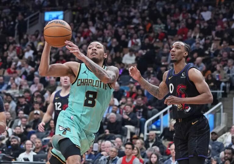 Apr 9, 2025; Toronto, Ontario, CAN; Charlotte Hornets guard Nick Smith Jr. (8) passes against Toronto Raptors guard A.J. Lawson (0) during the third quarter at Scotiabank Arena. Mandatory Credit: Nick Turchiaro-Imagn Images