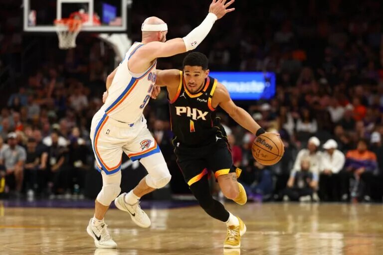 Apr 9, 2025; Phoenix, Arizona, USA; Phoenix Suns guard Devin Booker (1) dribbles the ball against Oklahoma City Thunder guard Alex Caruso (9) during the first half at Footprint Center. Mandatory Credit: Mark J. Rebilas-Imagn Images