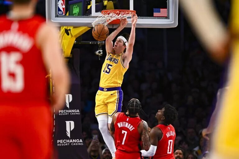Apr 11, 2025; Los Angeles, California, USA; Los Angeles Lakers guard Austin Reaves (15) dunks against Houston Rockets forward Cam Whitmore (7) and guard Aaron Holiday (0) during the second half at Crypto.com Arena. Mandatory Credit: Jonathan Hui-Imagn Images