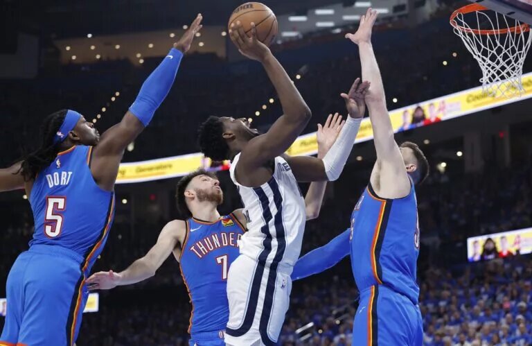 Apr 22, 2025; Oklahoma City, Oklahoma, USA; Memphis Grizzlies forward Jaren Jackson Jr. (13) shoots between Oklahoma City Thunder guard Luguentz Dort (5), forward Chet Holmgren (7), and center Isaiah Hartenstein (55) in the third quarter during game two of first round for the 2024 NBA Playoffs at Paycom Center. Mandatory Credit: Alonzo Adams-Imagn Images