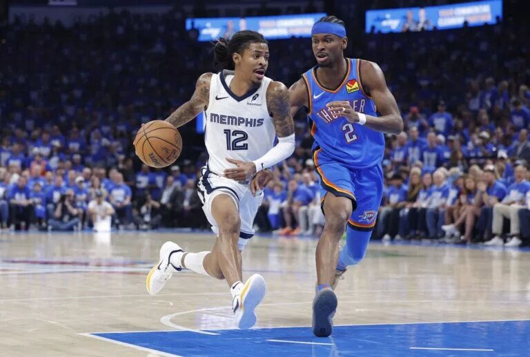 Apr 22, 2025; Oklahoma City, Oklahoma, USA; Memphis Grizzlies guard Ja Morant (12) drives to the basket beside Oklahoma City Thunder guard Shai Gilgeous-Alexander (2) in the third quarter during game two of first round for the 2024 NBA Playoffs at Paycom Center. Mandatory Credit: Alonzo Adams-Imagn Images