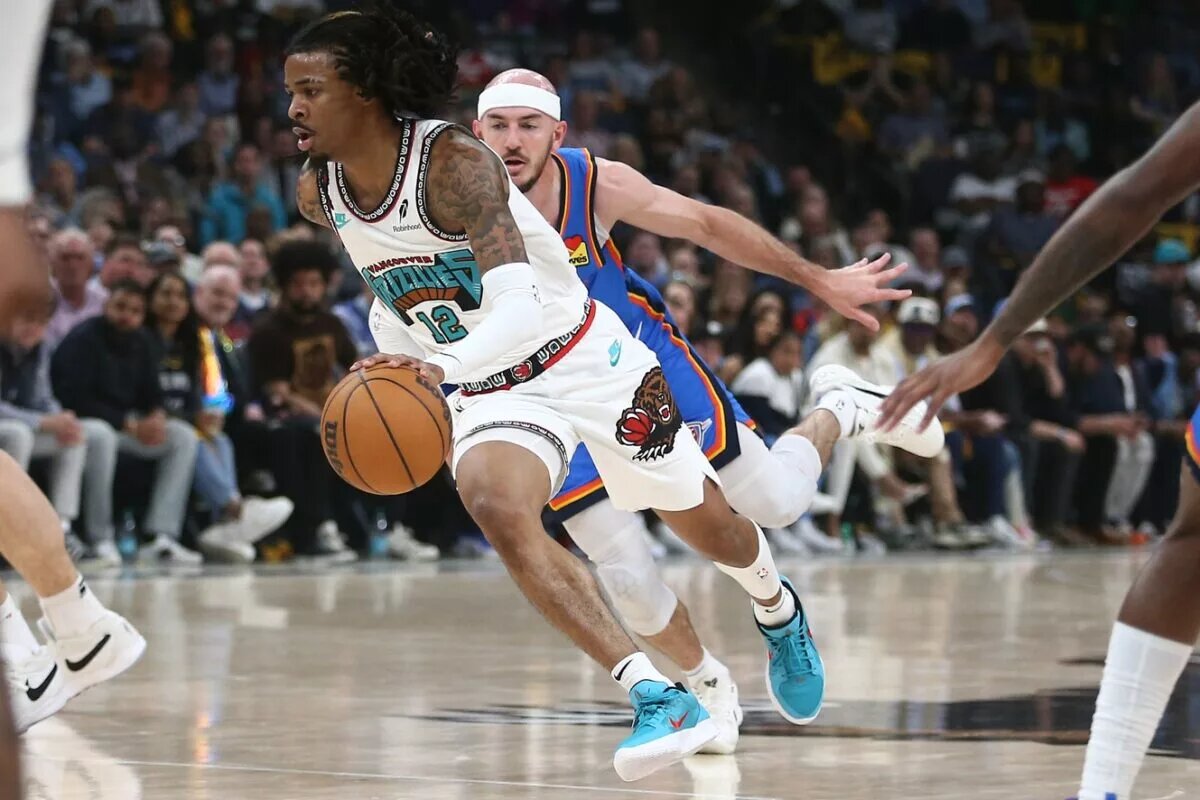Apr 24, 2025; Memphis, Tennessee, USA; Memphis Grizzlies guard Ja Morant (12) drives to the basket as Oklahoma City Thunder guard Alex Caruso (9) defends during the second quarter during game three for the first round of the 2024 NBA Playoffs at FedExForum. Mandatory Credit: Petre Thomas-Imagn Images