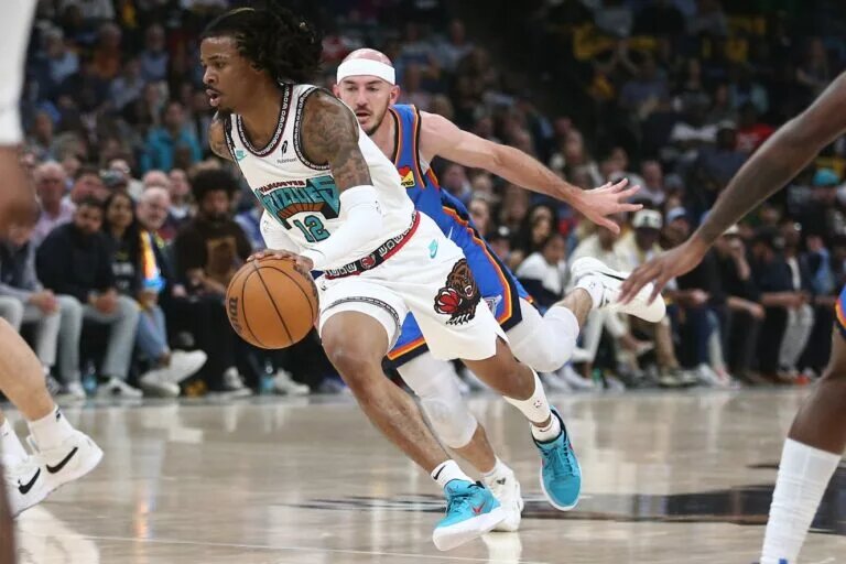 Apr 24, 2025; Memphis, Tennessee, USA; Memphis Grizzlies guard Ja Morant (12) drives to the basket as Oklahoma City Thunder guard Alex Caruso (9) defends during the second quarter during game three for the first round of the 2024 NBA Playoffs at FedExForum. Mandatory Credit: Petre Thomas-Imagn Images