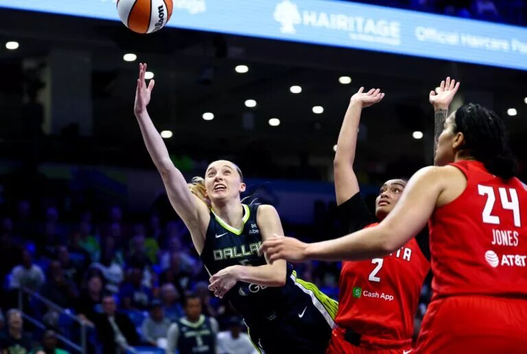 Jul 30, 2025; Arlington, Texas, USA; Dallas Wings guard Paige Bueckers (5) scores past Atlanta Dream guard Te-Hina Paopao (2) and Atlanta Dream forward Brionna Jones (24) during the second half at College Park Center. Mandatory Credit: Kevin Jairaj-Imagn Images