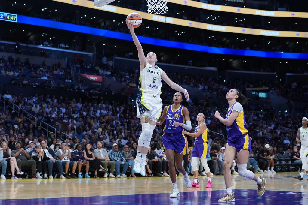 Aug 20, 2025; Los Angeles, California, USA; Dallas Wings guard Paige Bueckers (5) shoots the ball against LA Sparks forward Dearica Hamby (5) and forward Azura Stevens (23) in the first half at Crypto.com Arena. Mandatory Credit: Kirby Lee-Imagn Images