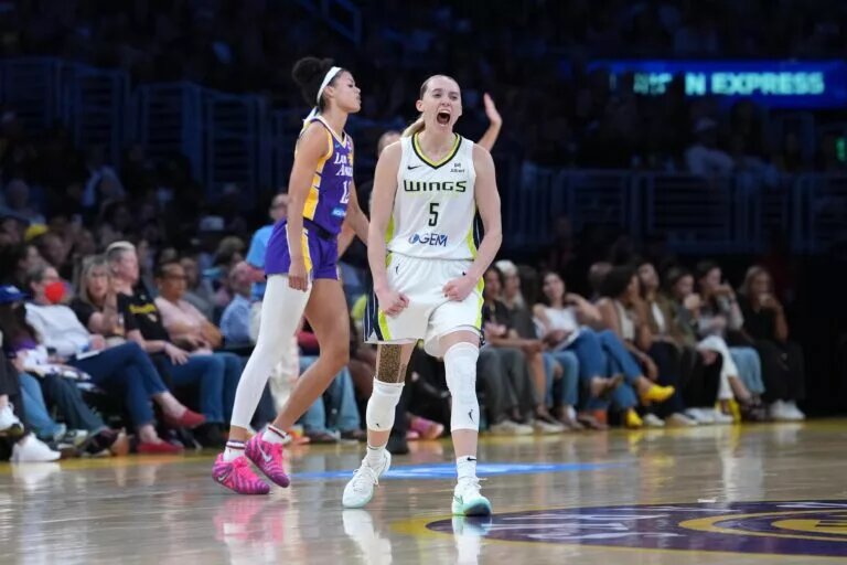 Aug 20, 2025; Los Angeles, California, USA; Dallas Wings guard Paige Bueckers (5) celebrates in the second half as LA Sparks guard Rae Burrell (12) watches at Crypto.com Arena. Mandatory Credit: Kirby Lee-Imagn Images