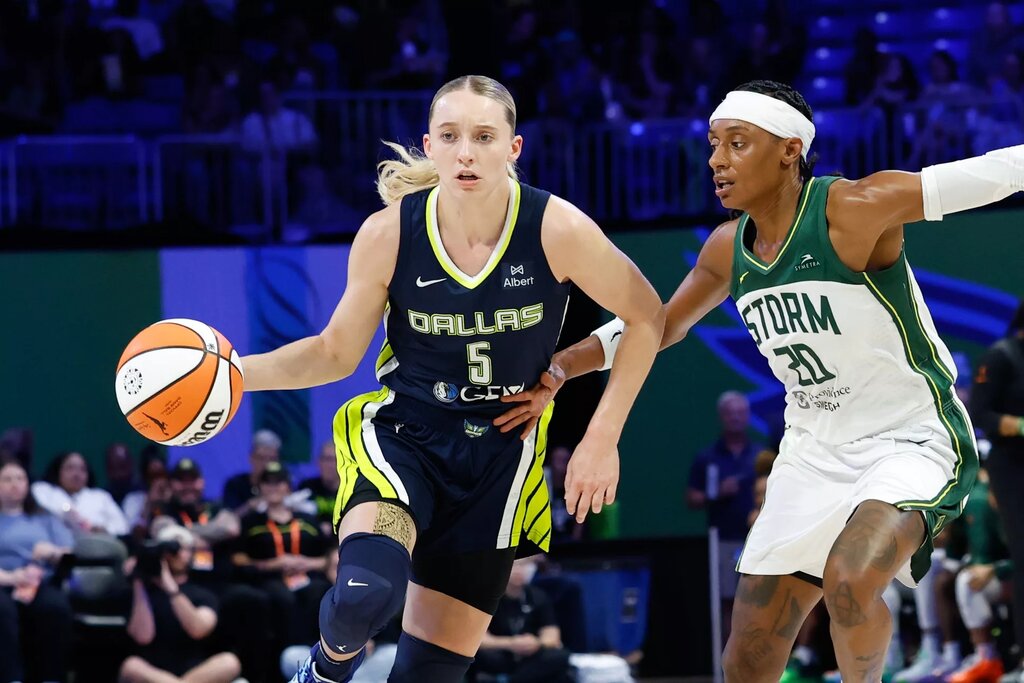 Aug 22, 2025; Arlington, Texas, USA; Dallas Wings guard Paige Bueckers (5) controls the ball as Seattle Storm guard Brittney Sykes (20) defends during the second half at College Park Center. Mandatory Credit: Chris Jones-Imagn Images