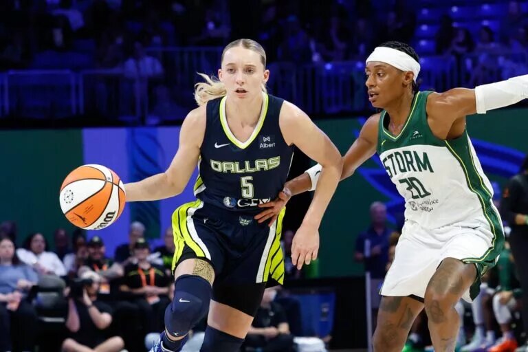 Aug 22, 2025; Arlington, Texas, USA; Dallas Wings guard Paige Bueckers (5) controls the ball as Seattle Storm guard Brittney Sykes (20) defends during the second half at College Park Center. Mandatory Credit: Chris Jones-Imagn Images