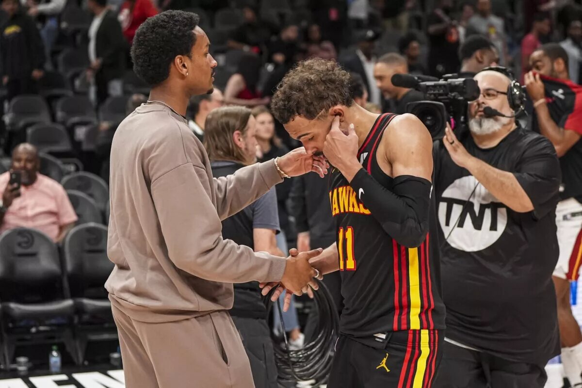 Atlanta Hawks guard Trae Young (11) reacts with injured player Kobe Bufkin
