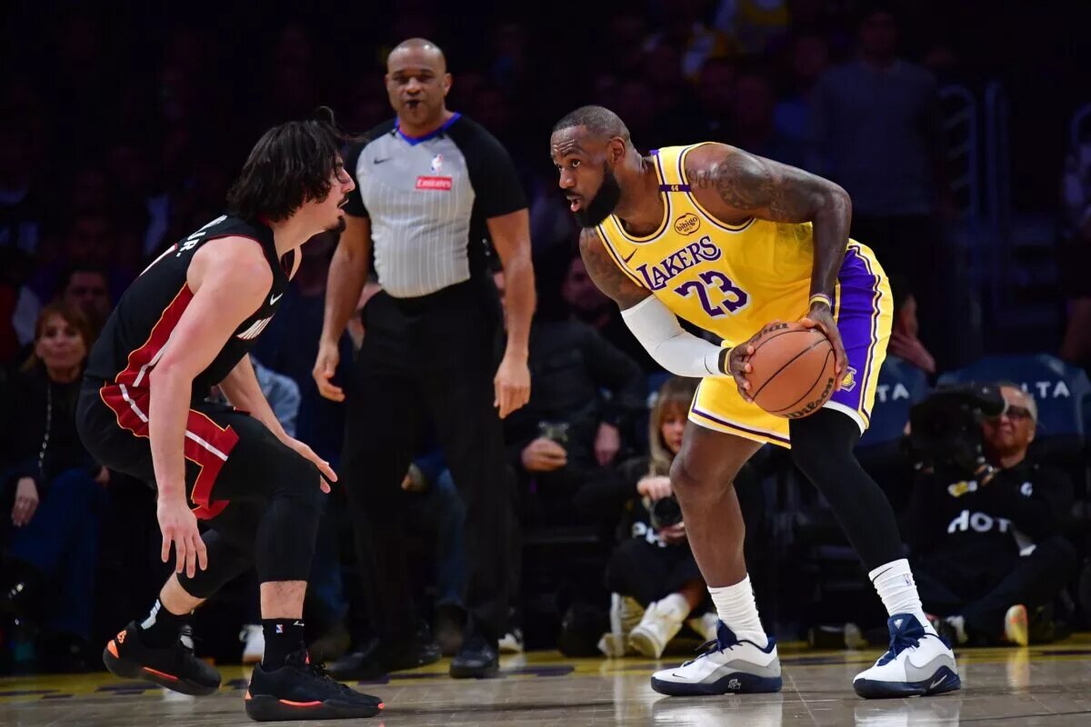 January 15, 2025; Los Angeles, California, USA; Los Angeles Lakers forward LeBron James (23) controls the ball against Miami Heat guard Jaime Jaquez Jr. (11) during the first half at Crypto.com Arena. Mandatory Credit: Gary A. Vasquez-Imagn Images