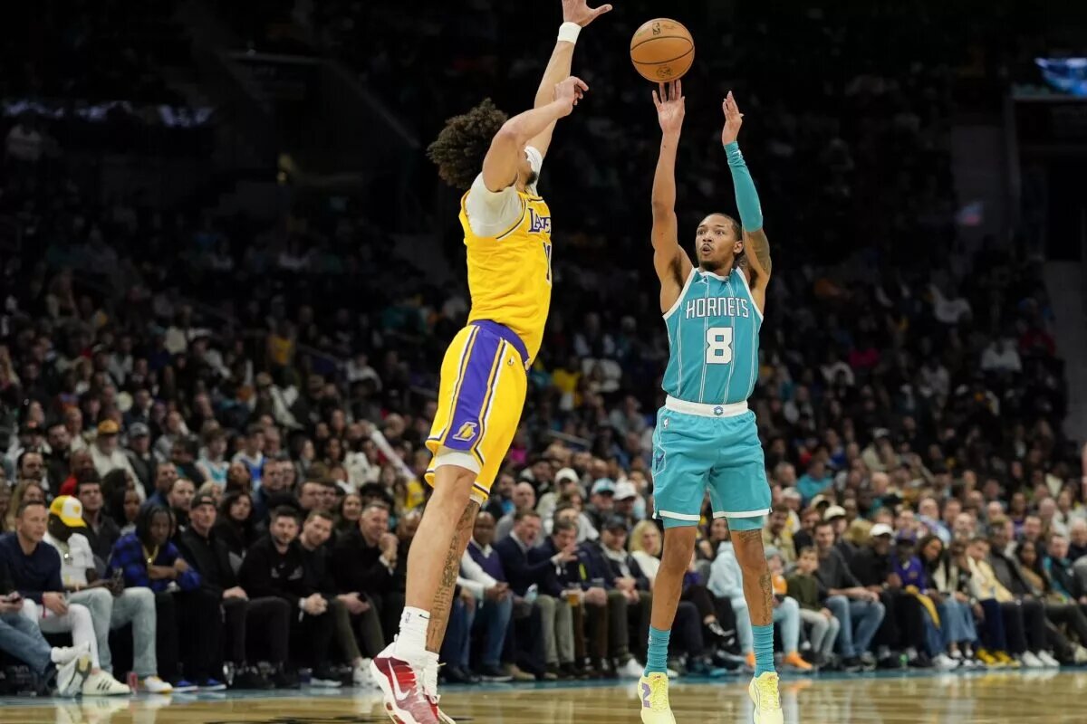 Jan 27, 2025; Charlotte, North Carolina, USA; Charlotte Hornets guard Nick Smith Jr. (8) shoots a jumper over Los Angeles Lakers center Jaxson Hayes (11)during the second half at the Spectrum Center. Mandatory Credit: Jim Dedmon-Imagn Images