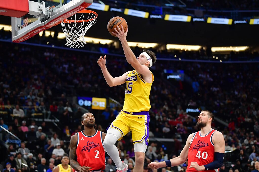 Feb 4, 2025; Inglewood, California, USA; Los Angeles Lakers guard Austin Reaves (15) scores a basket ahead of Los Angeles Clippers forward Kawhi Leonard (2) and center Ivica Zubac (40) during the second half at Intuit Dome. Mandatory Credit: Gary A. Vasquez-Imagn Images