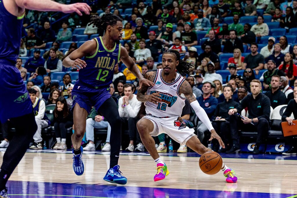 Mar 9, 2025; New Orleans, Louisiana, USA; Memphis Grizzlies guard Ja Morant (12) dribbles against New Orleans Pelicans guard Antonio Reeves (12) during the second half at Smoothie King Center. Mandatory Credit: Stephen Lew-Imagn Images