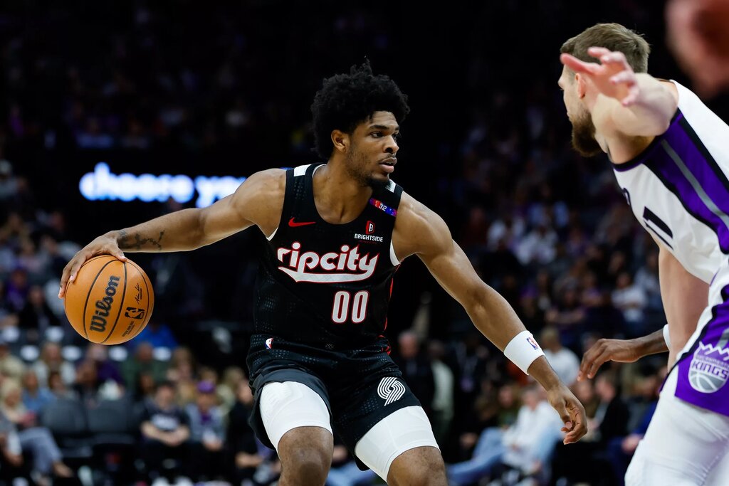 Mar 27, 2025; Sacramento, California, USA; Portland Trail Blazers guard Scoot Henderson (00) dribbles against Sacramento Kings forward Domantas Sabonis (11) during the third quarter at Golden 1 Center. Mandatory Credit: Sergio Estrada-Imagn Images