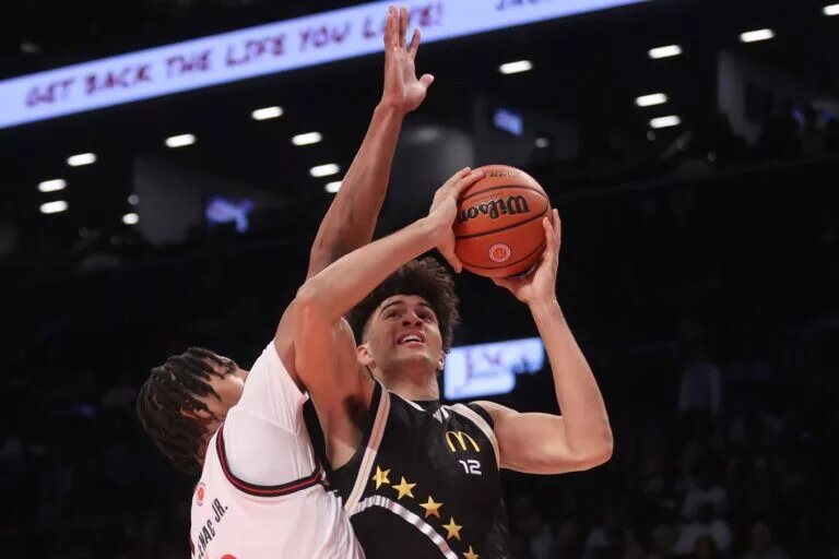 Apr 1, 2025; Brooklyn, NY, USA; McDonald's All American East forward Cameron Boozer (12) shoots the ball against McDonald's All American West center Chris Cenac Jr. (1) during the second half of the game at Barclays Center. Mandatory Credit: Pamela Smith-Imagn Images