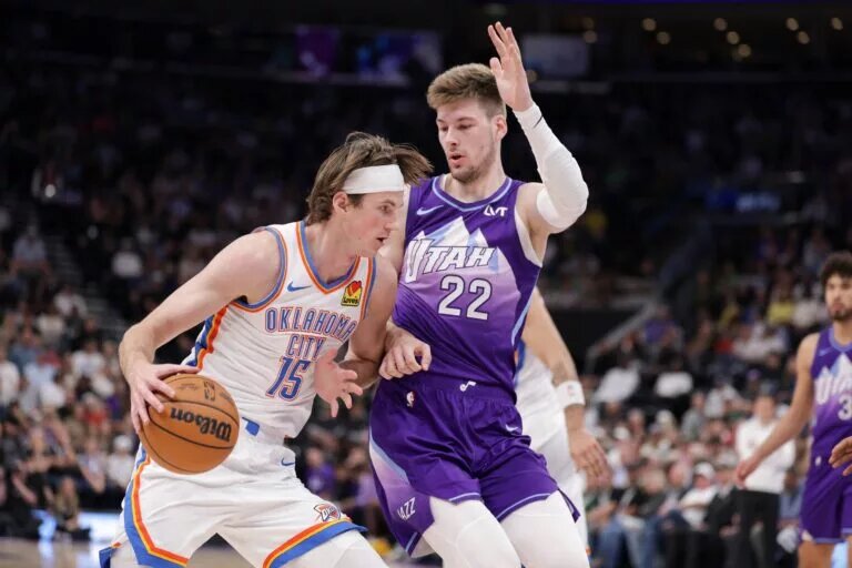 Apr 11, 2025; Salt Lake City, Utah, USA; Oklahoma City Thunder center Branden Carlson (15) tries to dribble past Utah Jazz forward Kyle Filipowski (22) during the second quarter at Delta Center. Mandatory Credit: Chris Nicoll-Imagn Images