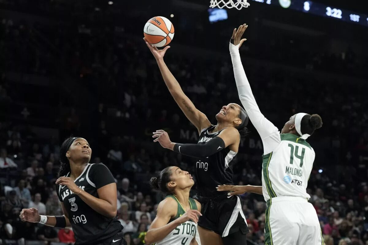 Sep 18, 2025; Las Vegas, Nevada, USA; Las Vegas Aces center A'ja Wilson (22) shoots against Seattle Storm center Dominique Malonga (14) in the first quarter during game three of round one for the 2025 WNBA Playoffs at Michelob Ultra Arena. Mandatory Credit: Candice Ward-Imagn Images