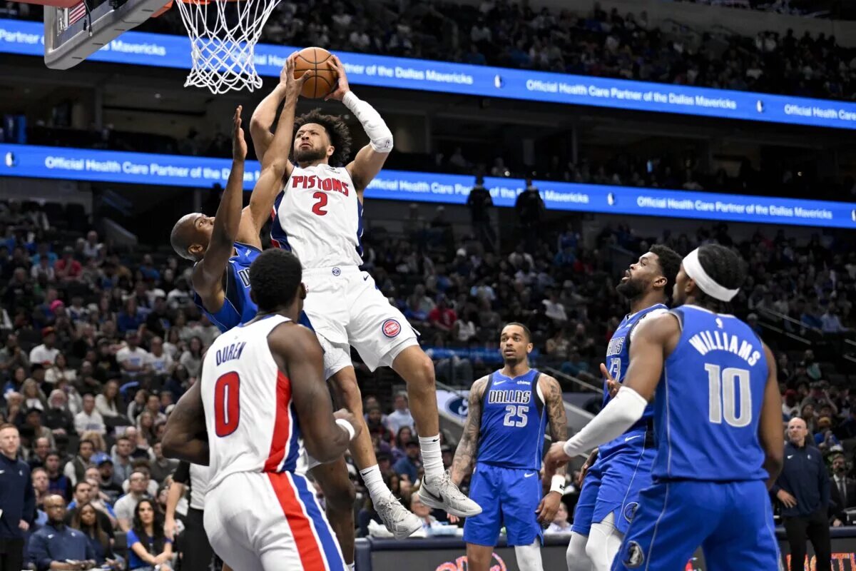 Mar 21, 2025; Dallas, Texas, USA; Detroit Pistons guard Cade Cunningham (2) shoots the ball over Dallas Mavericks forward Kai Jones (23) as forward P.J. Washington (25) and forward Naji Marshall (13) and guard Brandon Williams (10) look on during the second half at the American Airlines Center. Mandatory Credit: Jerome Miron-Imagn Images