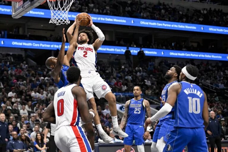 Mar 21, 2025; Dallas, Texas, USA; Detroit Pistons guard Cade Cunningham (2) shoots the ball over Dallas Mavericks forward Kai Jones (23) as forward P.J. Washington (25) and forward Naji Marshall (13) and guard Brandon Williams (10) look on during the second half at the American Airlines Center. Mandatory Credit: Jerome Miron-Imagn Images