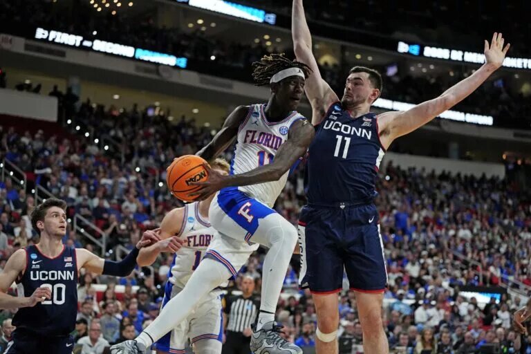 Mar 23, 2025; Raleigh, NC, USA; Florida Gators guard Denzel Aberdeen (11) drives to the basket as Connecticut Huskies forward Alex Karaban (11) defends during the second half in the second round of the NCAA Tournament at Lenovo Center. Mandatory Credit: Bob Donnan-Imagn Images