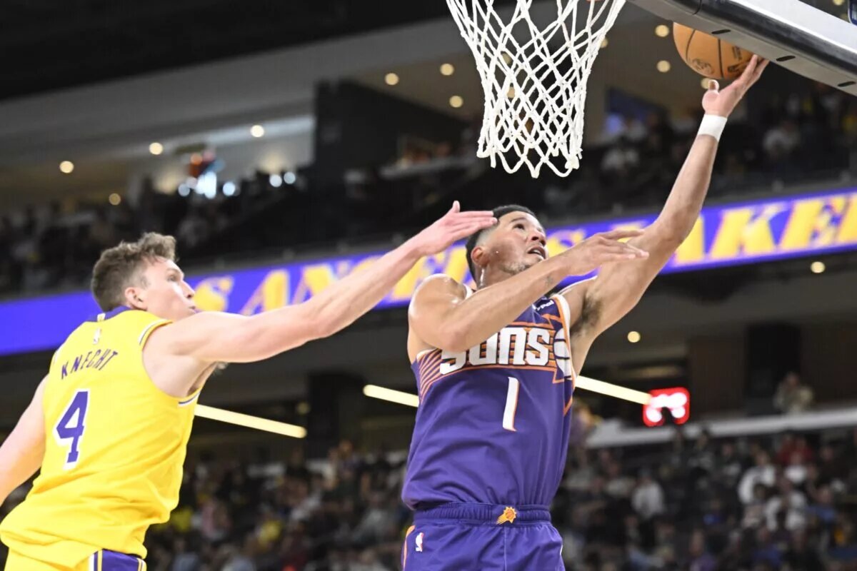 Oct 3, 2025; Palm Desert, California, USA; Phoenix Suns guard Devin Booker (1) shoots past Los Angeles Lakers guard Dalton Knecht (4) at Acrisure Arena. Mandatory Credit: Denis Poroy-Imagn Images