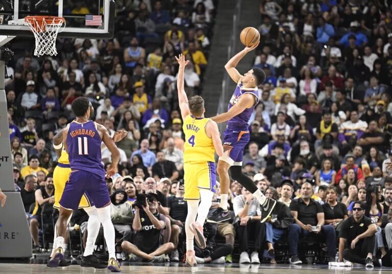 Oct 3, 2025; Palm Desert, California, USA; Phoenix Suns guard Devin Booker (1) shoots over Los Angeles Lakers guard Dalton Knecht (4) during the first half at Acrisure Arena. Mandatory Credit: Denis Poroy-Imagn Images