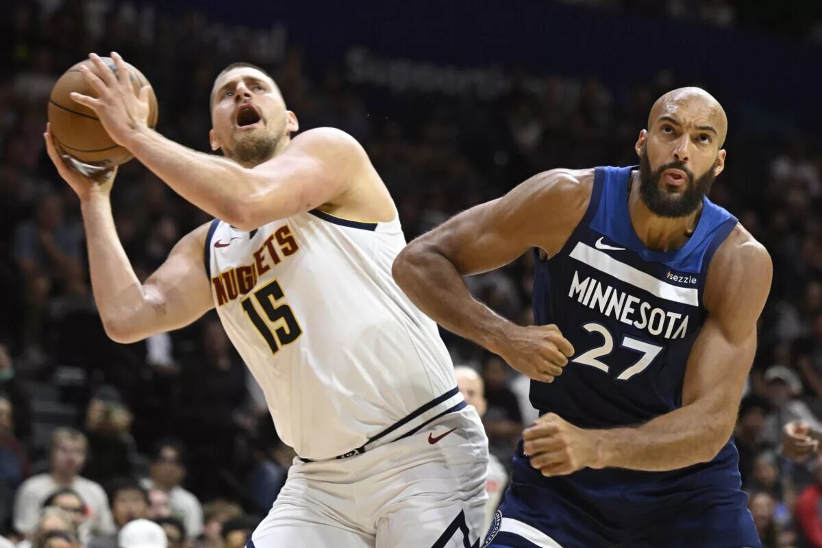 Denver Nuggets center Nikola Jokic attempts to score against Minnesota Timberwolves center Rudy Gobert