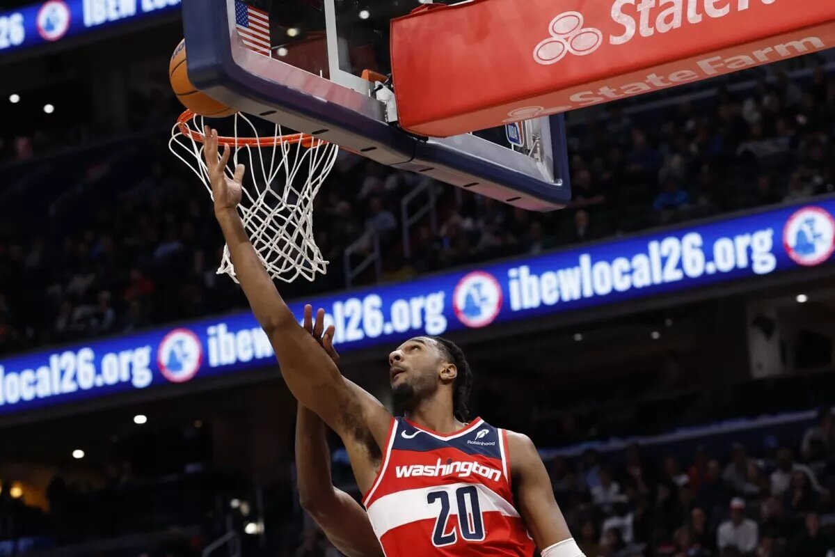 Oct 28, 2025; Washington, District of Columbia, USA; Washington Wizards center Alex Sarr (20) shoots the ball as Philadelphia 76ers center Joel Embiid (21) defends in the fourth quarter at Capital One Arena. Mandatory Credit: Geoff Burke-Imagn Images