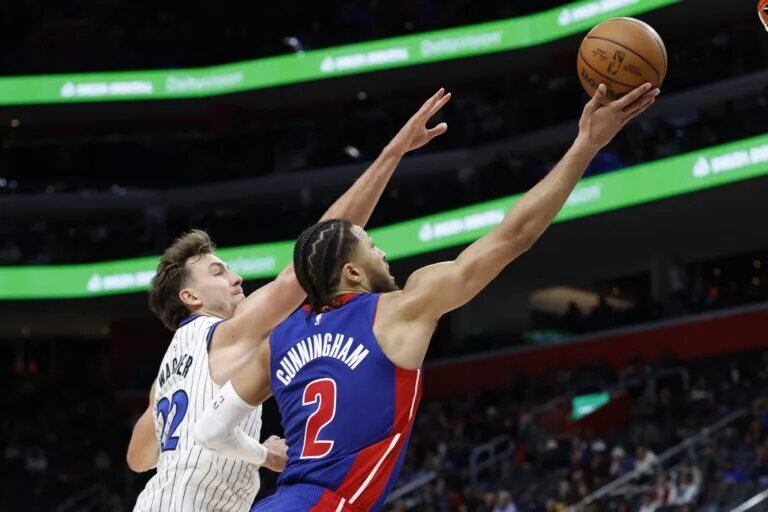 Oct 29, 2025; Detroit, Michigan, USA; Detroit Pistons guard Cade Cunningham (2) shoots on Orlando Magic forward Franz Wagner (22) in the second half at Little Caesars Arena. Mandatory Credit: Rick Osentoski-Imagn Images
