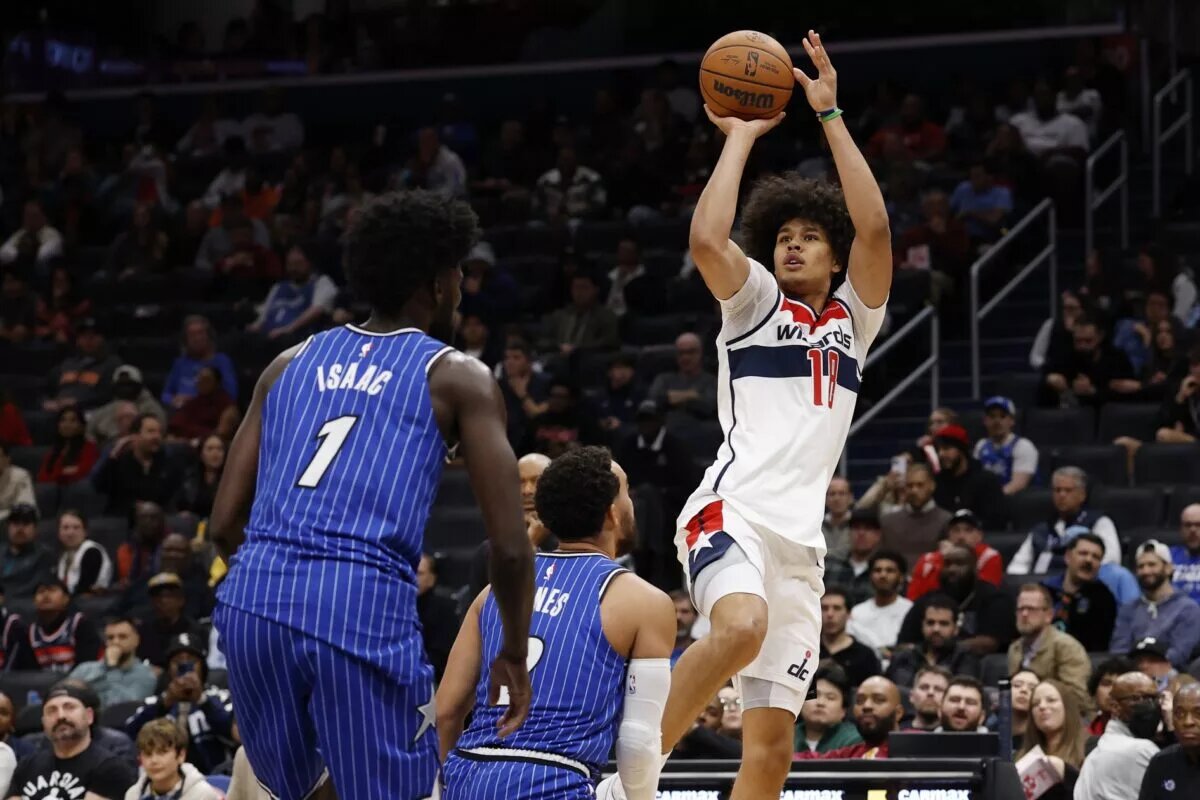 Nov 1, 2025; Washington, District of Columbia, USA; Washington Wizards forward Kyshawn George (18) shoots the ball over Orlando Magic guard Tyus Jones (2) in the second half at Capital One Arena. Mandatory Credit: Geoff Burke-Imagn Images