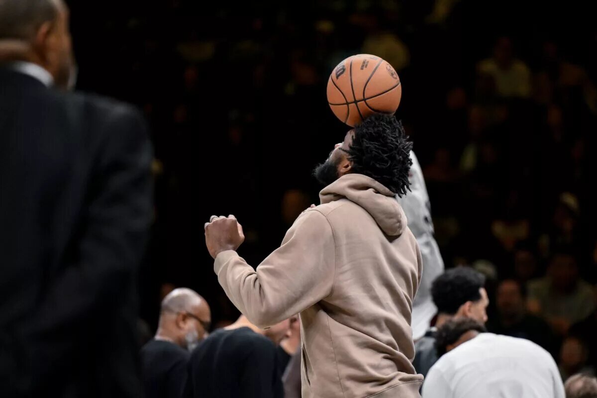 Philadelphia 76ers center Joel Embiid (21) balances a basketball on his head as his team has a timeout during the second half against the Brooklyn Nets at Barclays Center.