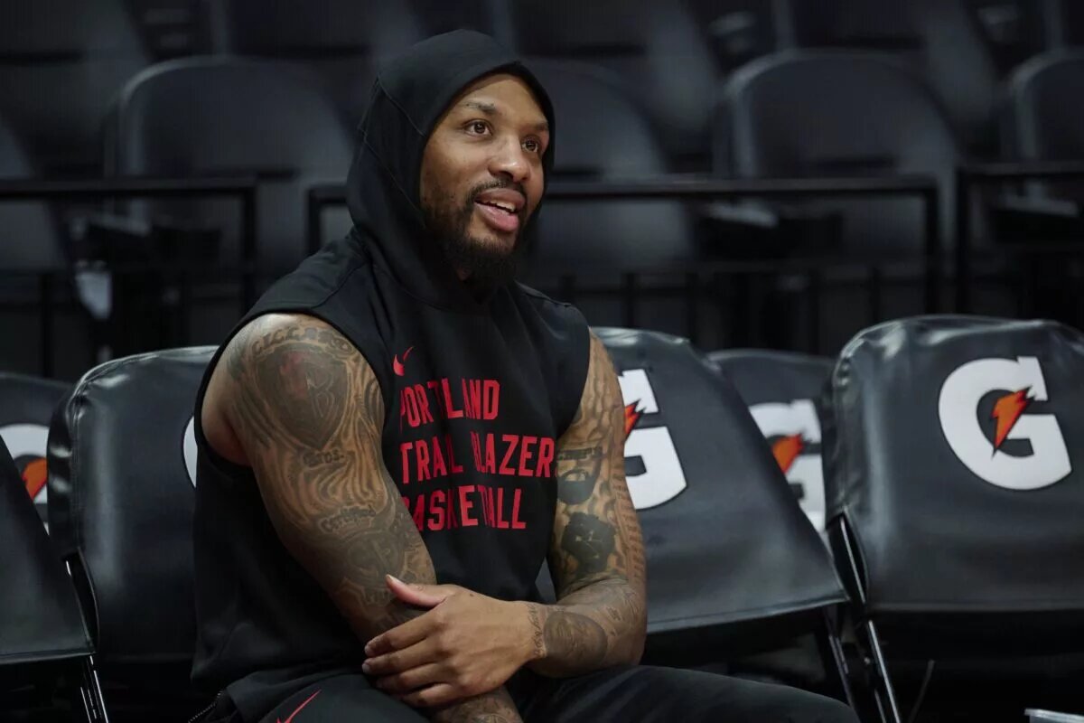 Portland Trail Blazers guard Damian Lillard (0) watches teammates warm up before a game against the Los Angeles Lakers at Moda Center.