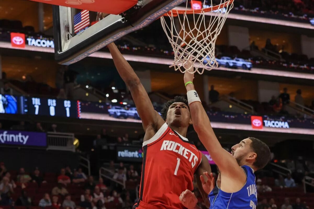 Nov 3, 2025; Houston, Texas, USA; Houston Rockets guard Amen Thompson (1) scores against Dallas Mavericks guard Klay Thompson (31) in the first quarter at Toyota Center. Mandatory Credit: Thomas Shea-Imagn Images