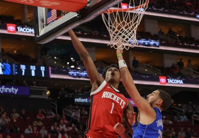 Nov 3, 2025; Houston, Texas, USA; Houston Rockets guard Amen Thompson (1) scores against Dallas Mavericks guard Klay Thompson (31) in the first quarter at Toyota Center. Mandatory Credit: Thomas Shea-Imagn Images