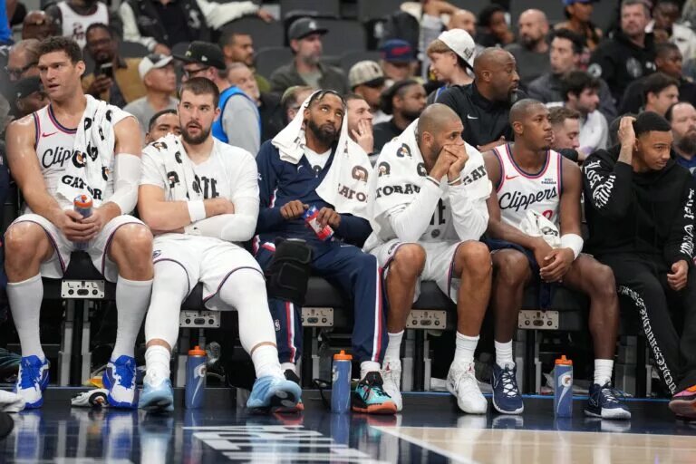 LA Clippers players (from left) center Brook Lopez (11), center Ivica Zubac (40), forward Derrick Jones Jr. (5), forward Nicolas Batum (33) and guard Kris Dunn (8) watch on the bench against the Oklahoma City Thunder in the second half at Intuit Dome.
