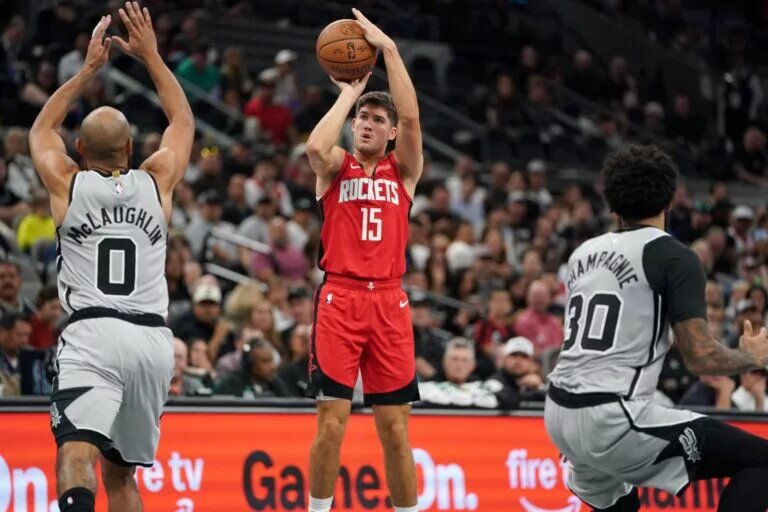 Nov 7, 2025; San Antonio, Texas, USA; Houston Rockets guard Reed Sheppard (15) shoots against San Antonio Spurs guard Jordan McLaughin (0) during the second quarter at Frost Bank Center. Mandatory Credit: Dustin Safranek-Imagn Images