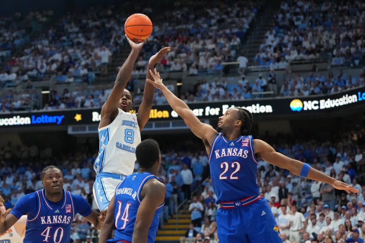 North Carolina Tar Heels forward Caleb Wilson (8) shoots as Kansas Jayhawks forward Flory Bidunga (40) and guard Melvin Council Jr. (14) and guard Darryn Peterson (22) defend in the second half at Dean E. Smith Center.