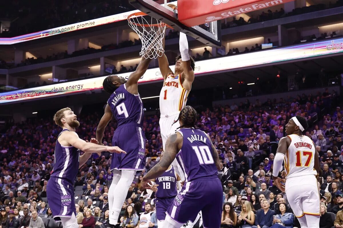 Nov 12, 2025; Sacramento, California, USA; Atlanta Hawks forward Jalen Johnson (1) dunks the ball against Sacramento Kings forward Precious Achiuwa (9) during the second quarter at Golden 1 Center. Mandatory Credit: Kelley L Cox-Imagn Images