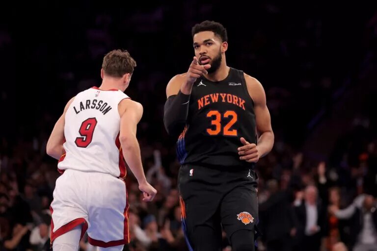 Nov 14, 2025; New York, New York, USA; New York Knicks center Karl-Anthony Towns (32) reacts after a three point shot against Miami Heat guard Pelle Larsson (9) during the second quarter at Madison Square Garden. Mandatory Credit: Brad Penner-Imagn Images