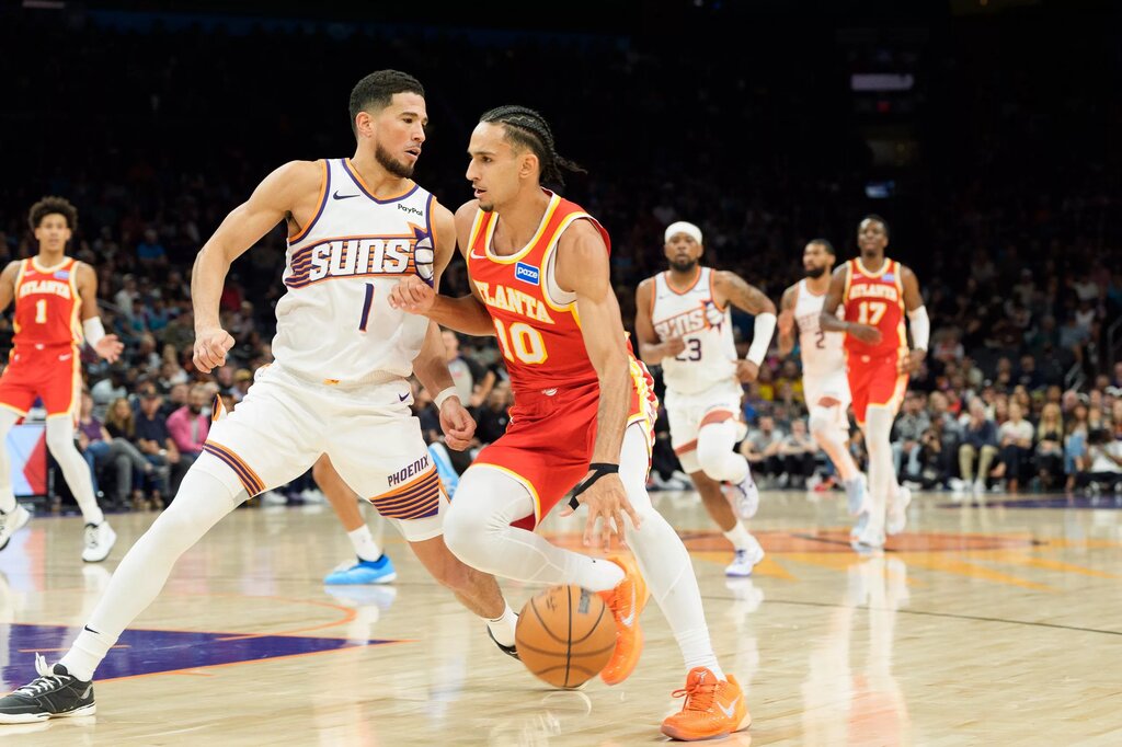 Atlanta Hawks forward Zaccharie Risacher (10) and drives as Phoenix Suns guard Devin Booker (1) defends during the second half of play during a game at Mortgage Matchup Center.