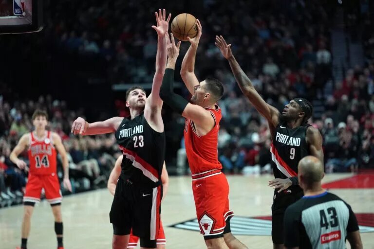 Nov 19, 2025; Portland, Oregon, USA; Portland Trail Blazers center Donovan Clingan (23) blocks the shot of Chicago Bulls center Nikola Vucevic (9) during the second half at Moda Center. Mandatory Credit: Soobum Im-Imagn Images