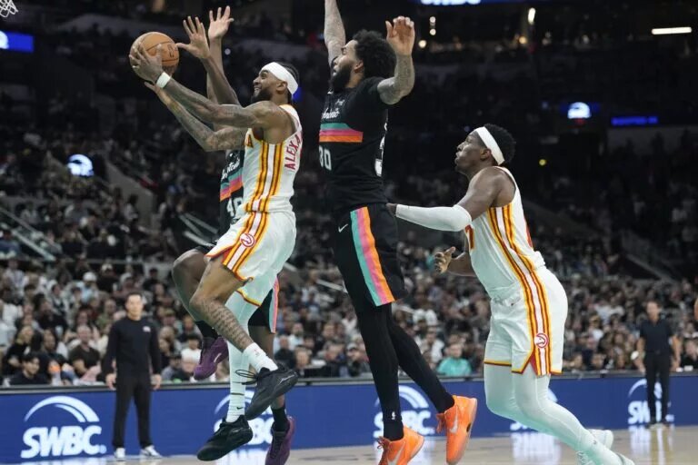 Nov 20, 2025; San Antonio, Texas, USA; Atlanta Hawks guard Nickeil Alexander-Walker (7) drives to the basket past San Antonio Spurs forward Julian Champagnie (30) during the second half at Frost Bank Center. Mandatory Credit: Scott Wachter-Imagn Images