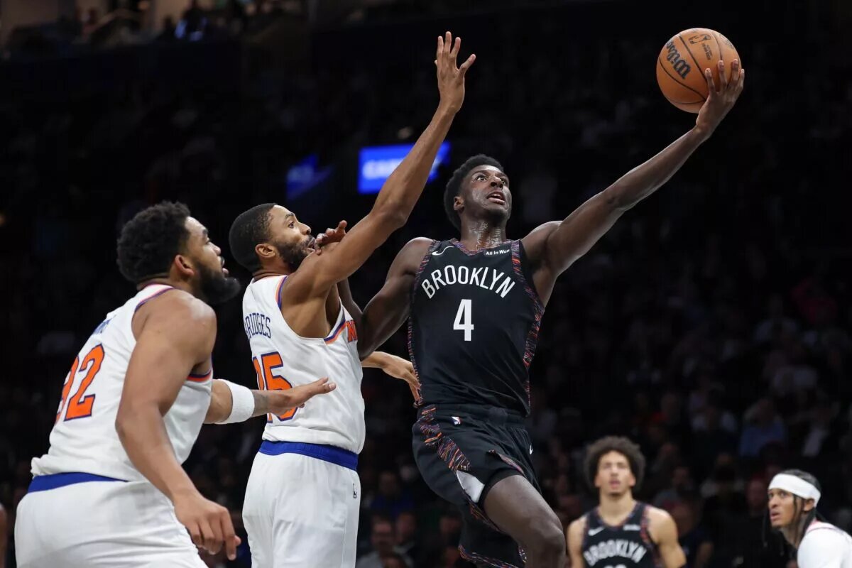 Nov 24, 2025; Brooklyn, New York, USA; Brooklyn Nets guard Drake Powell (4) goes to the basket as New York Knicks guard Mikal Bridges (25) defends during the second half at Barclays Center. Mandatory Credit: Vincent Carchietta-Imagn Images